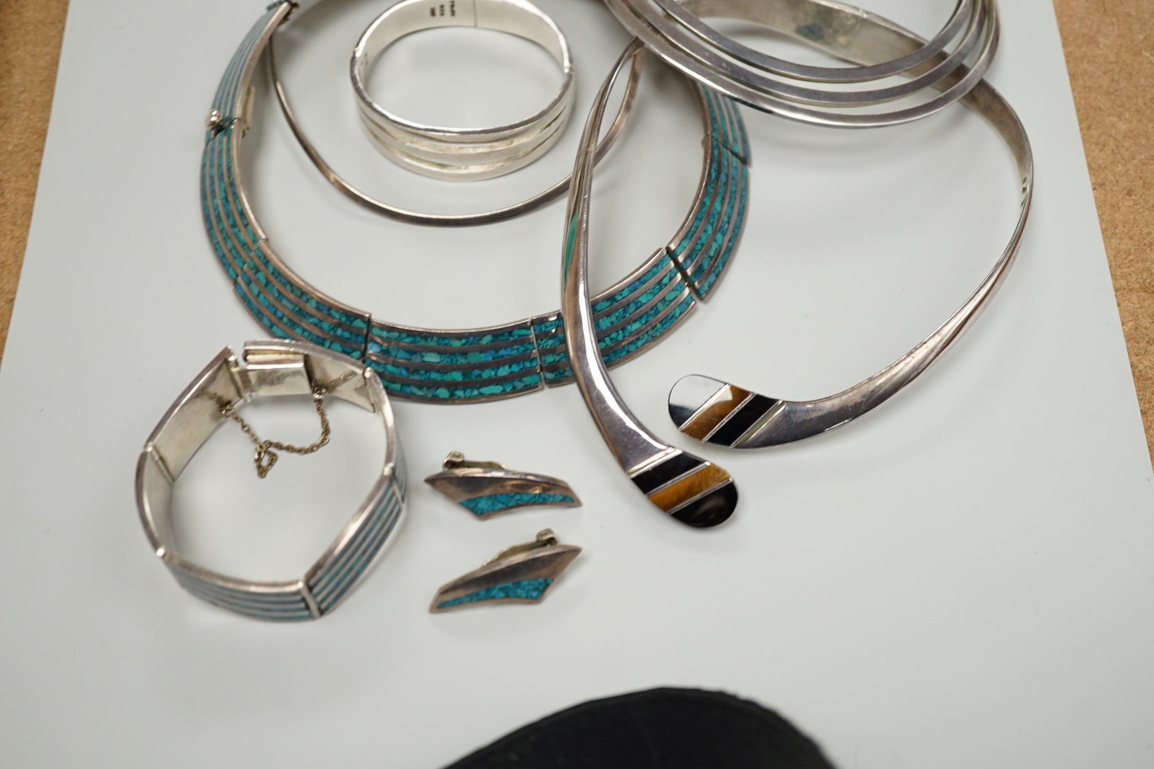 A Mexican 925 hinged necklet, 15.8cm (top to bottom) and matching bracelet, a similar suite of 925 and turquoise and enamel? jewellery, comprising a necklet, bracelet and pair of ear clips, a similar 925, black onyx and